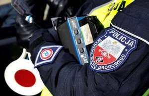 policjant w radiowozie, widoczny emblemat i tarcza