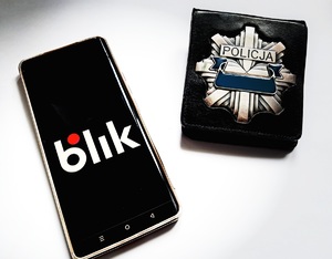 telefon (BLIK)  obok policyjna odznaka