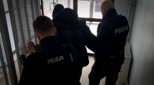 policjanci wyprowadzający z budynku KPP Ropczyce osobę podejrzaną