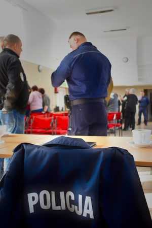 zdjęcie kurtki policyjnej, w tle policjant