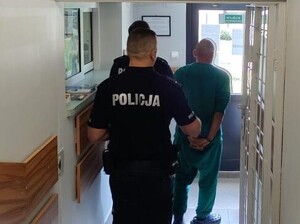Policjanci prowadzą zatrzymanego mężczyznę
